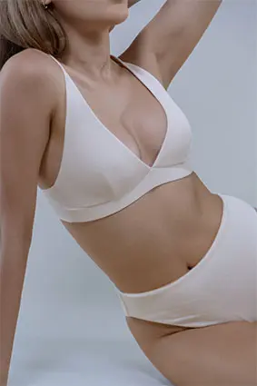 mia-nachher-2 Oberkörper einer Frau in weissem Bikini symbolisiert Brustvergrösserung mit natürlichem Ergebnis